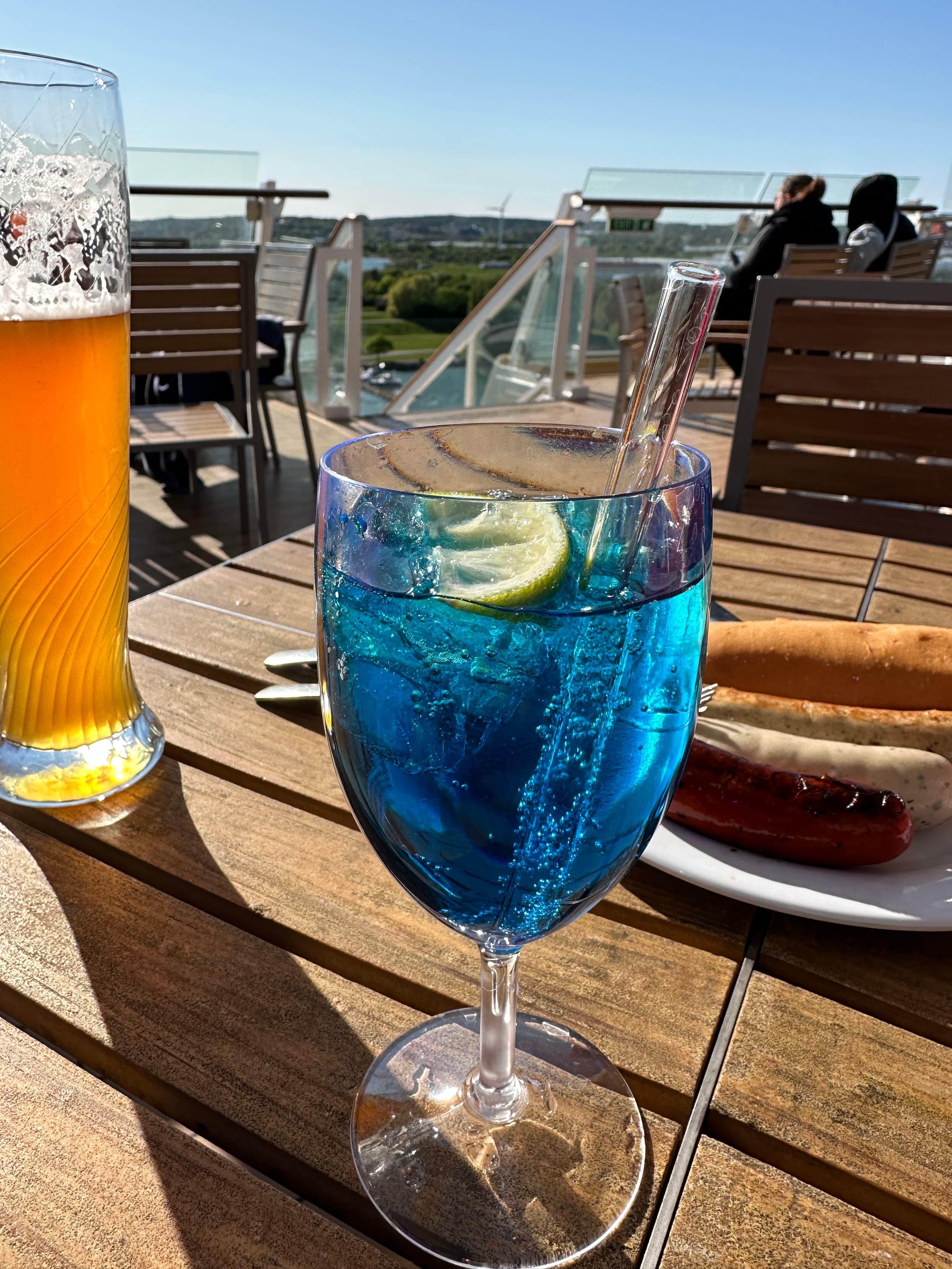 Blauer Cocktail an Deck mit Meerblick