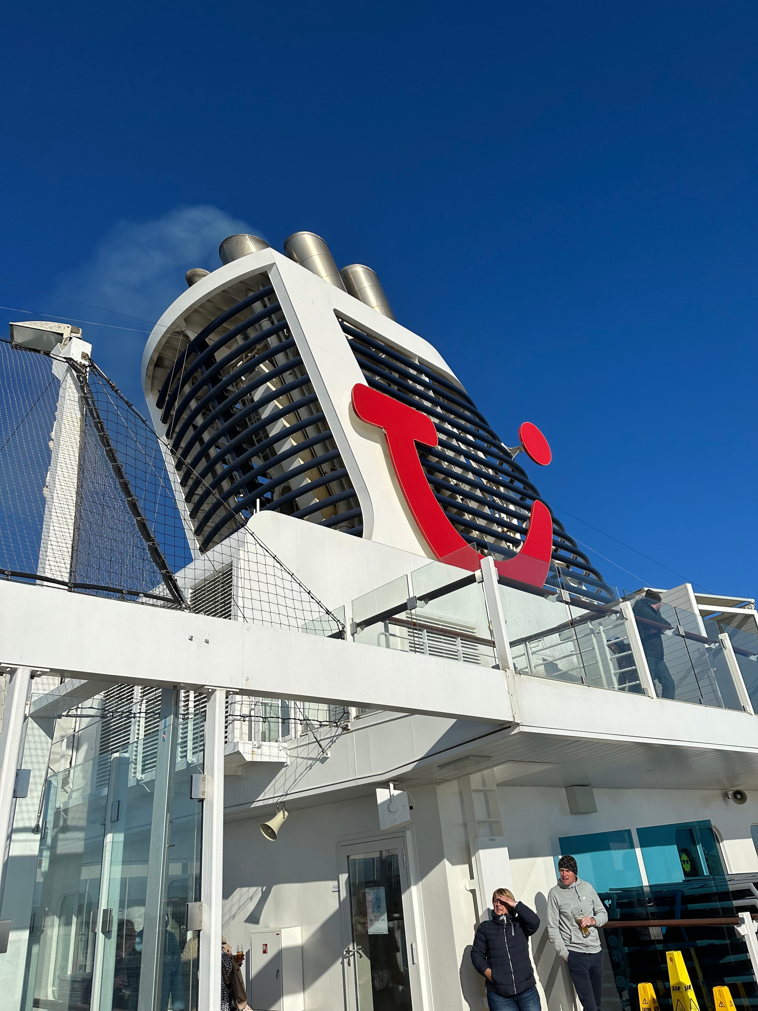 TUI Cruises Schornstein mit rotem Logo vor blauem Himmel
