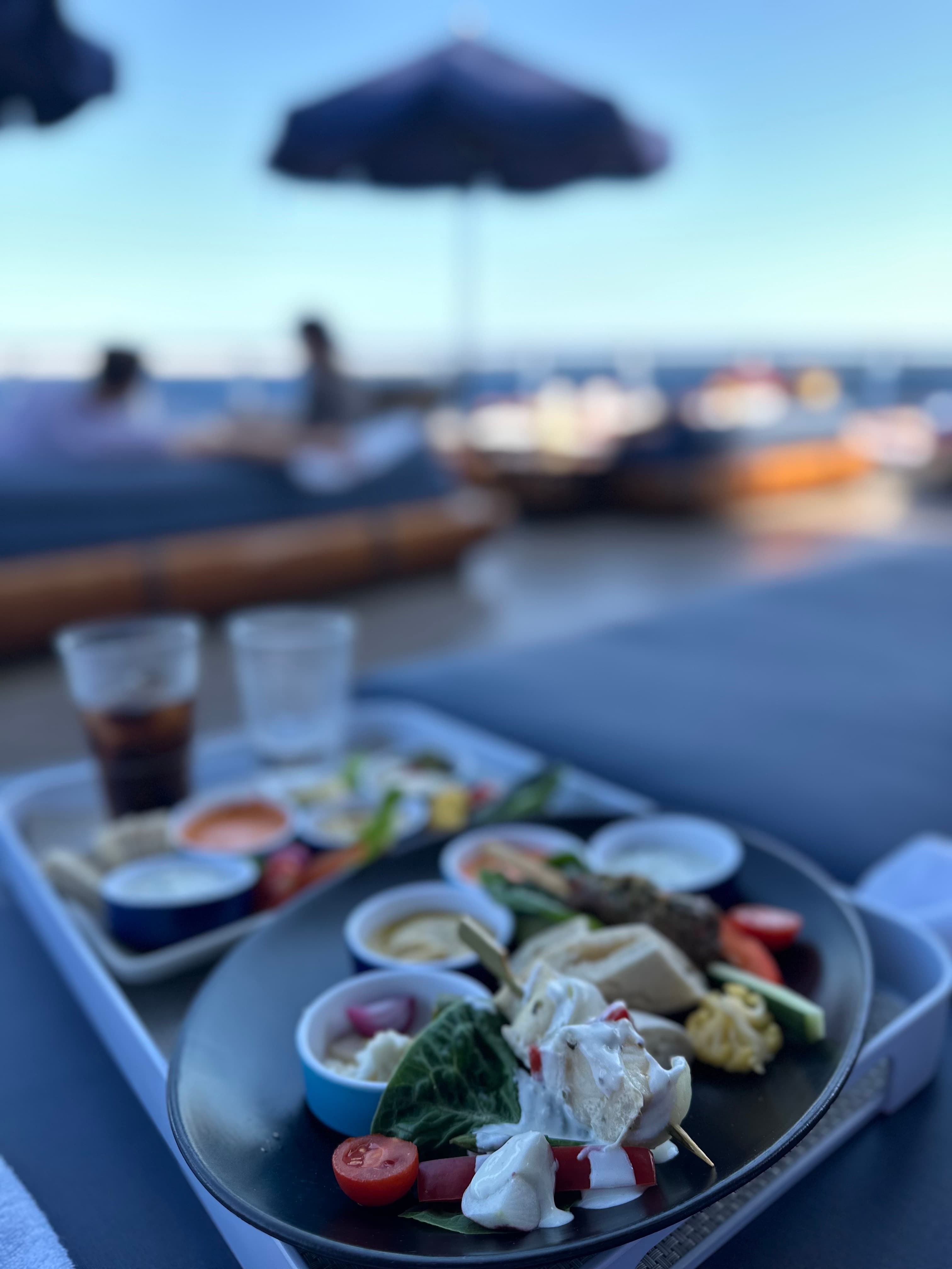 Snacks und Tapas auf Tablett an Deck mit Meerblick bei Sonnenuntergang